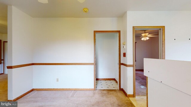 empty room with ceiling fan and light carpet