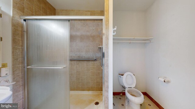 bathroom with tile patterned flooring, toilet, and an enclosed shower