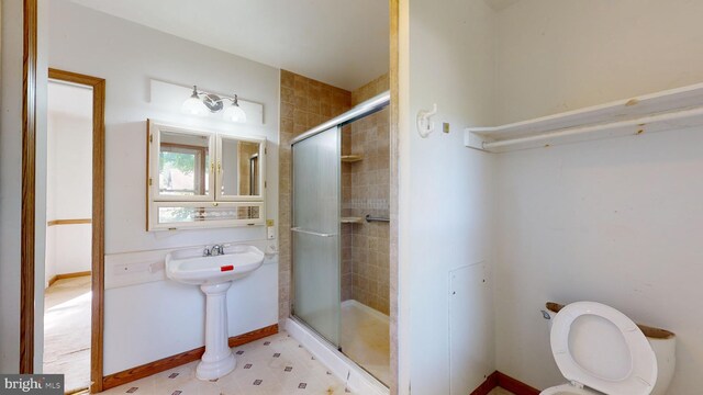 bathroom featuring tile patterned floors, an enclosed shower, sink, and toilet