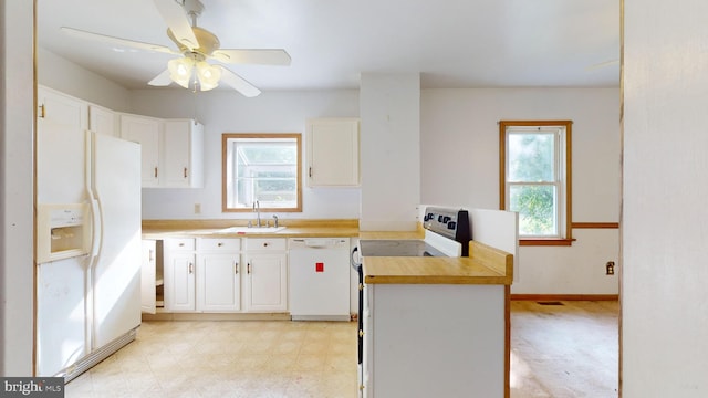 kitchen featuring sink, light tile patterned flooring, a healthy amount of sunlight, and white appliances