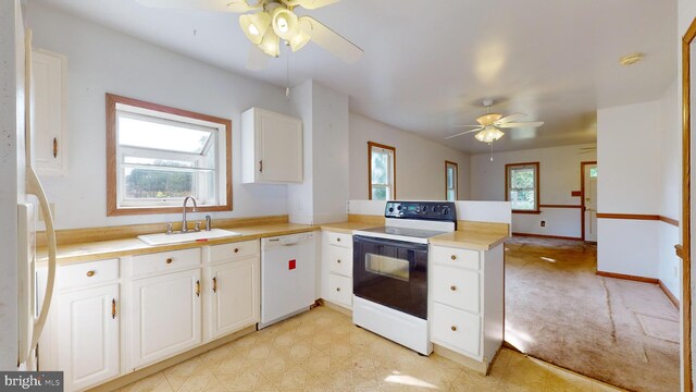 kitchen featuring sink, white cabinetry, white appliances, ceiling fan, and light colored carpet