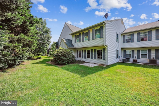 back of house featuring central AC and a lawn