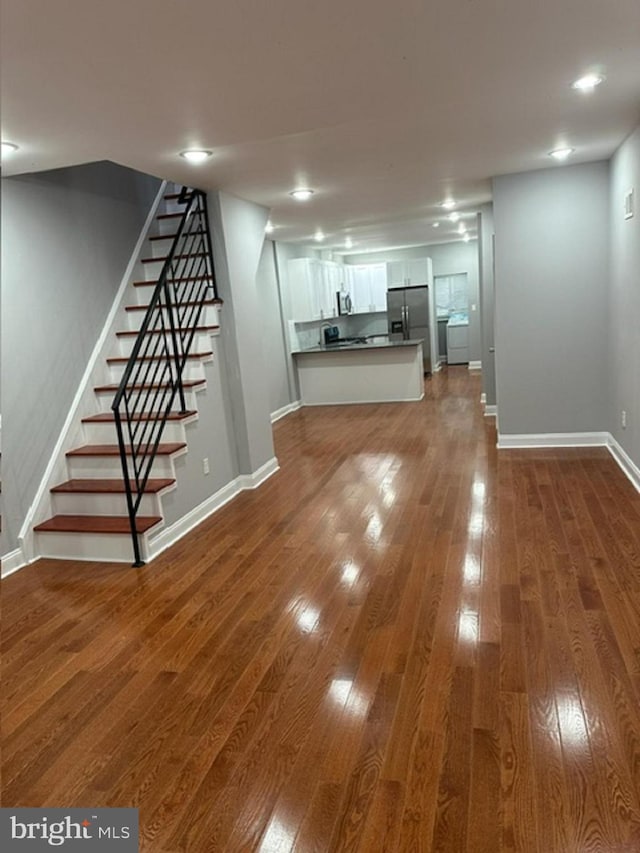 unfurnished living room with dark wood-type flooring