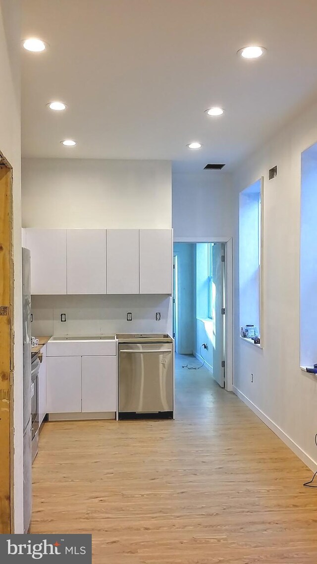 kitchen with light hardwood / wood-style flooring, white cabinetry, and stainless steel appliances