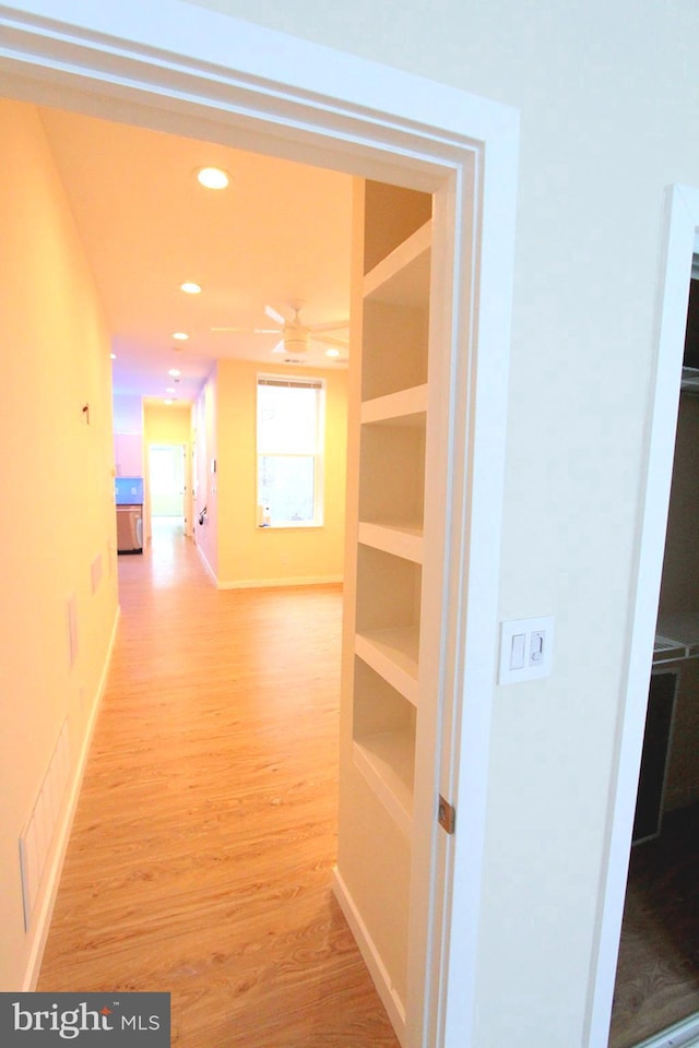 hallway with light hardwood / wood-style floors