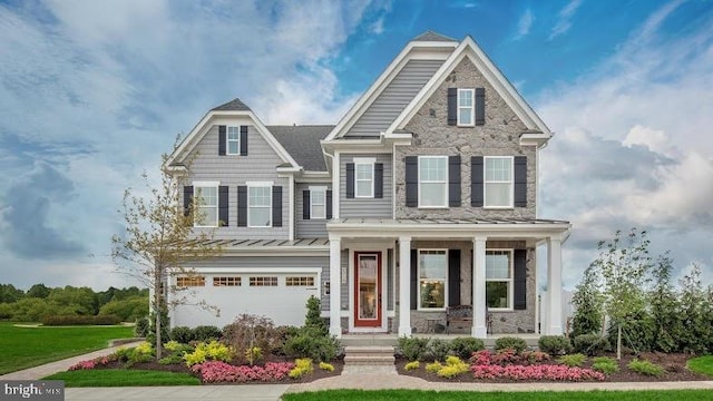 craftsman house with a garage, covered porch, and a front yard