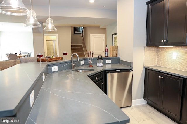 kitchen with tasteful backsplash, dark brown cabinets, sink, hanging light fixtures, and stainless steel dishwasher