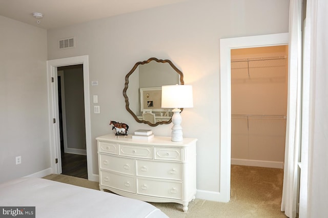 carpeted bedroom featuring a closet and a spacious closet