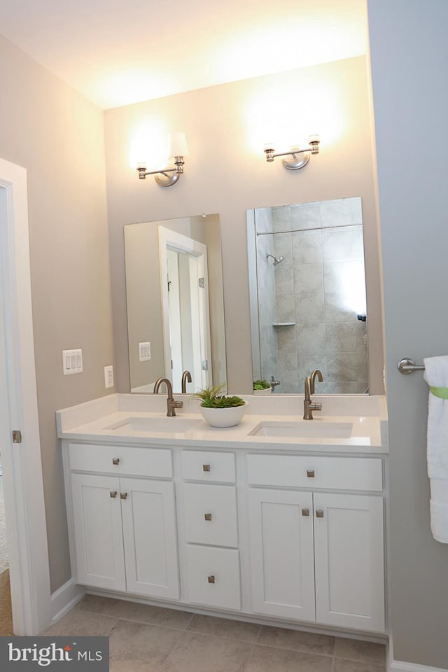 bathroom with tiled shower, vanity, and tile patterned flooring