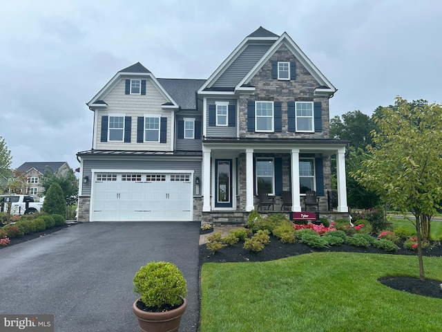 craftsman house featuring a front lawn, a garage, and covered porch