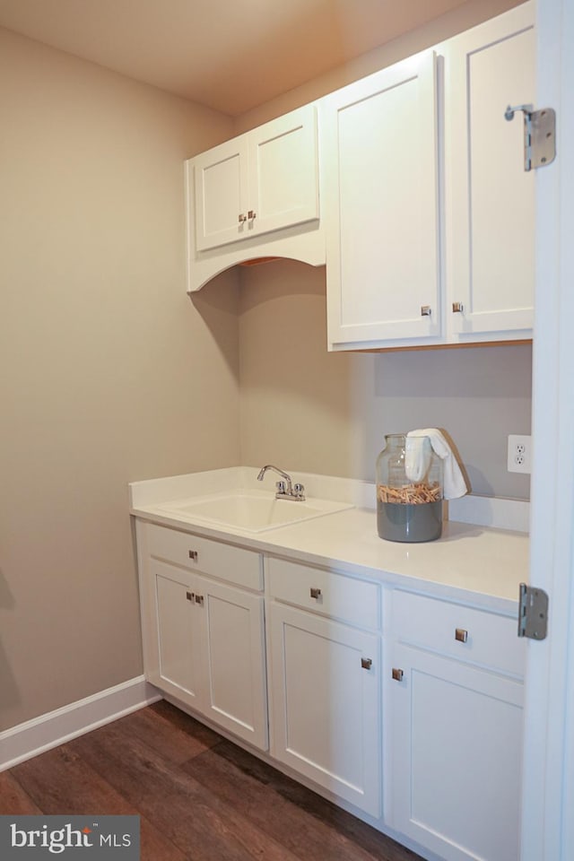 kitchen with dark hardwood / wood-style floors, sink, and white cabinets