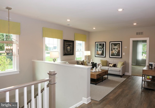 living room featuring a wealth of natural light and dark hardwood / wood-style flooring