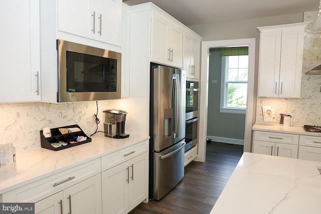 kitchen with dark hardwood / wood-style floors, light stone countertops, appliances with stainless steel finishes, and white cabinetry