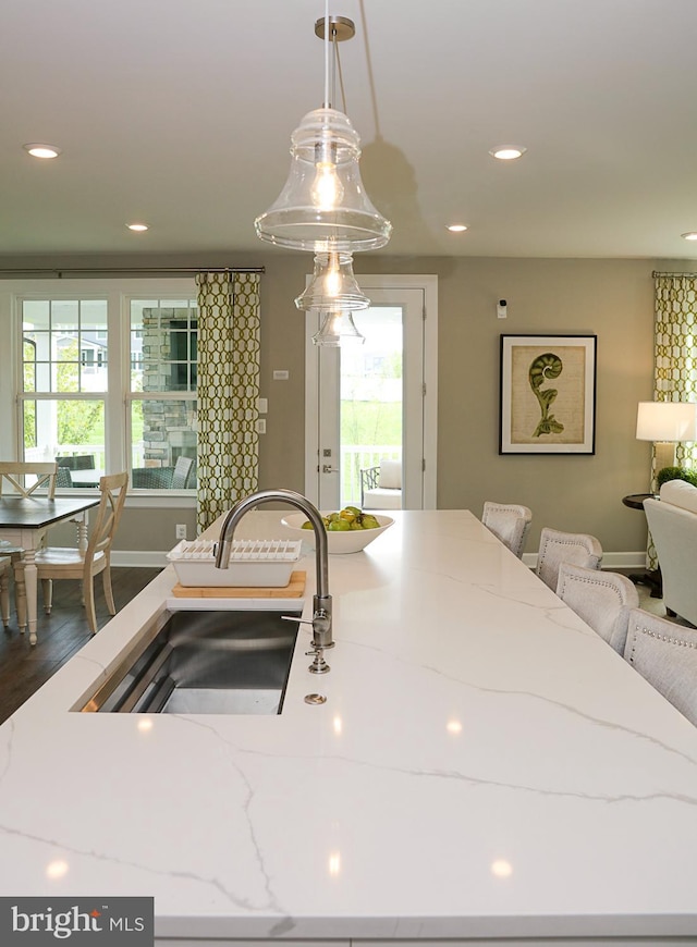 kitchen with pendant lighting, a healthy amount of sunlight, hardwood / wood-style floors, and sink