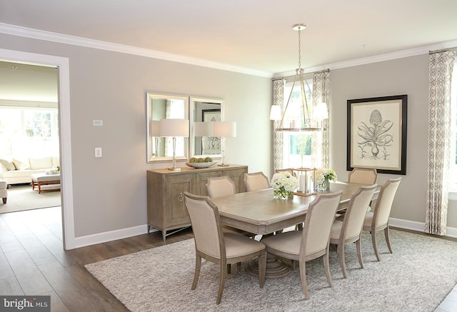 dining space with crown molding, dark wood-type flooring, and a chandelier