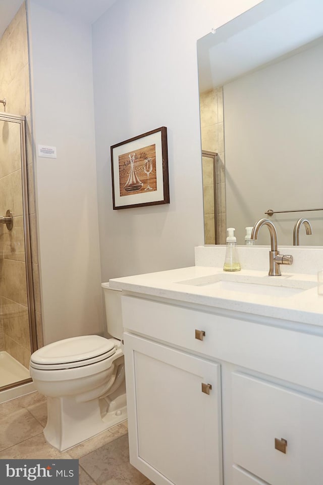 bathroom featuring vanity, toilet, tile patterned floors, and a shower with shower door