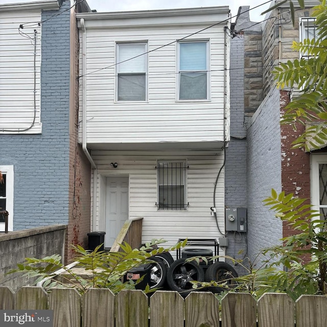 view of front of house featuring fence and brick siding