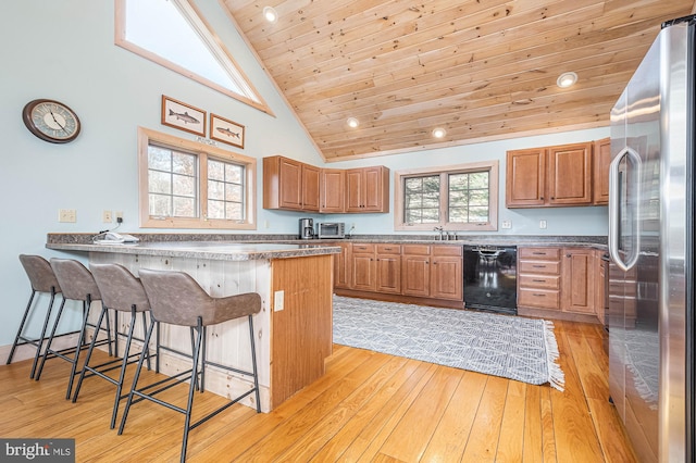 kitchen featuring high end refrigerator, a kitchen breakfast bar, high vaulted ceiling, light hardwood / wood-style flooring, and wood ceiling