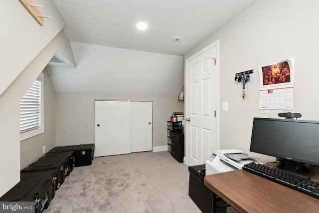 office with lofted ceiling and light colored carpet