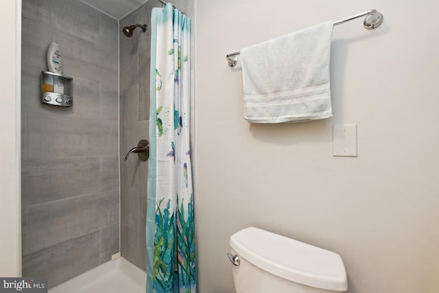 bathroom with curtained shower and toilet