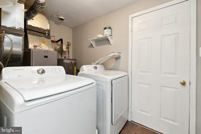 clothes washing area with water heater, separate washer and dryer, and dark tile patterned flooring