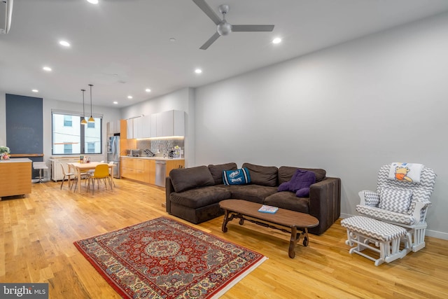 living room featuring light hardwood / wood-style flooring and ceiling fan