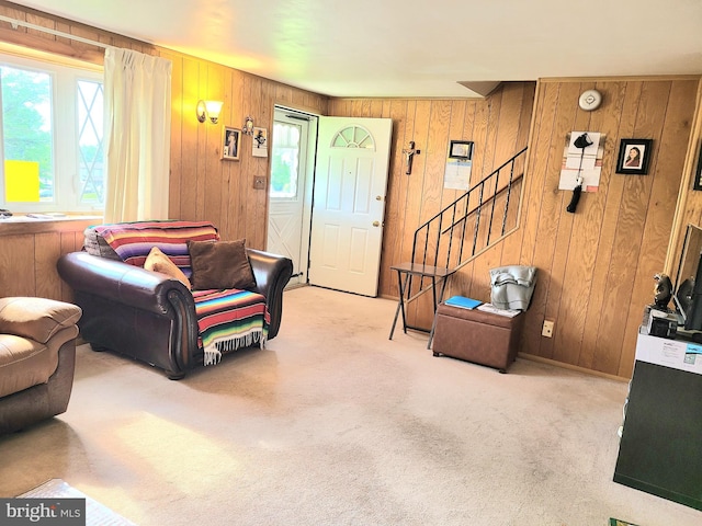 carpeted living room featuring wood walls and a wealth of natural light