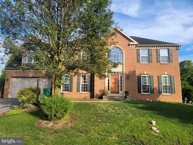 colonial house featuring a garage and a front yard