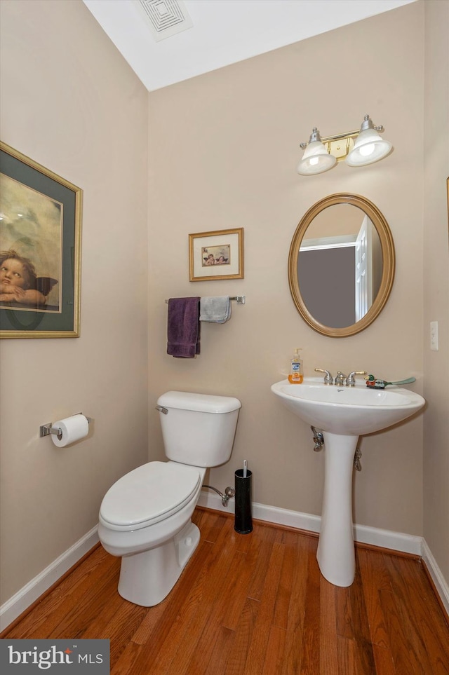 bathroom with toilet and hardwood / wood-style flooring