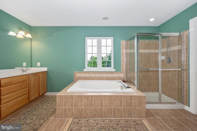 bathroom with tile patterned flooring, vanity, and plus walk in shower