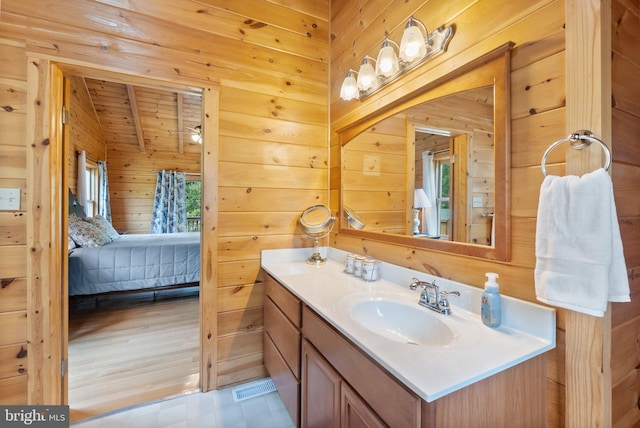 bathroom featuring vanity, wood walls, hardwood / wood-style floors, and wood ceiling