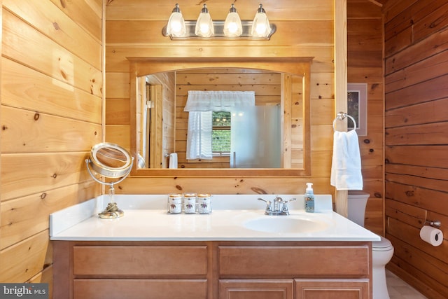 bathroom featuring wood walls, dual bowl vanity, and toilet