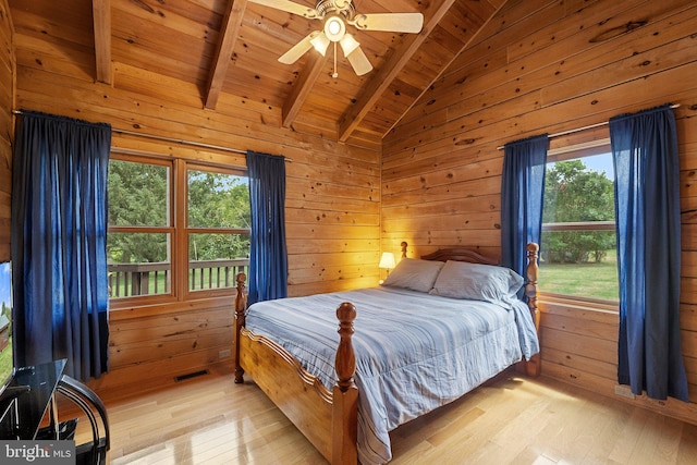 bedroom with lofted ceiling with beams, wooden walls, ceiling fan, wooden ceiling, and light hardwood / wood-style flooring