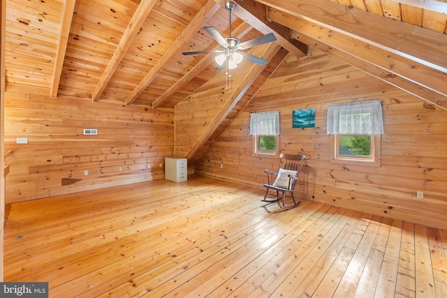 additional living space with wooden ceiling, wood walls, vaulted ceiling with beams, and light hardwood / wood-style floors