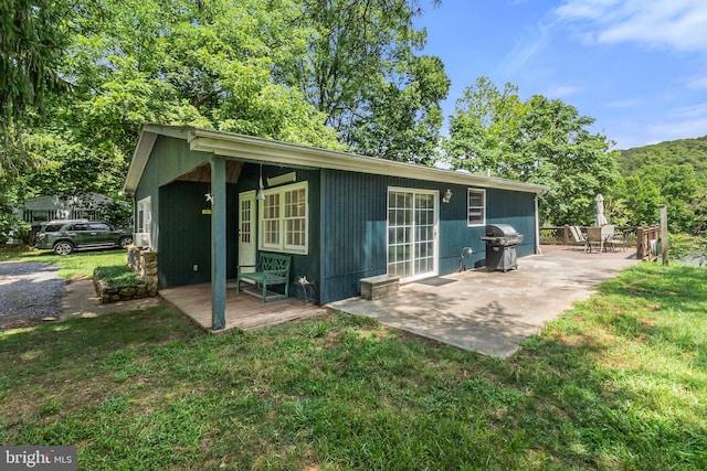 rear view of house with a lawn and a patio area