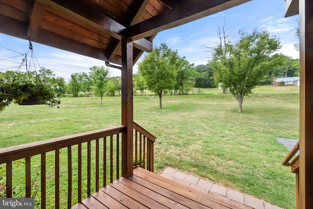 wooden deck featuring a lawn