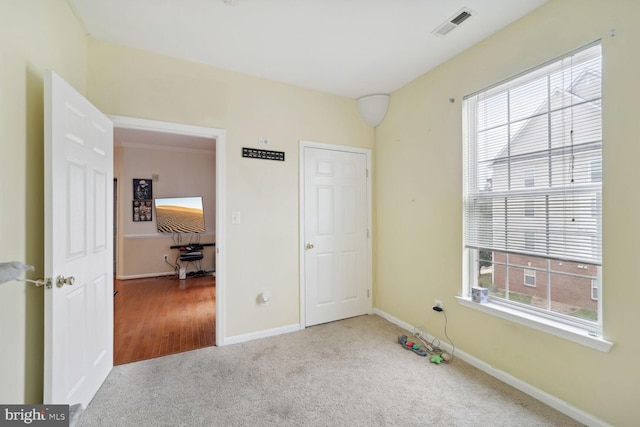 carpeted bedroom featuring multiple windows