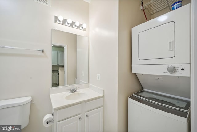 laundry room with stacked washer and clothes dryer and sink