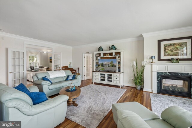 living room featuring dark hardwood / wood-style floors, ornamental molding, french doors, and a fireplace