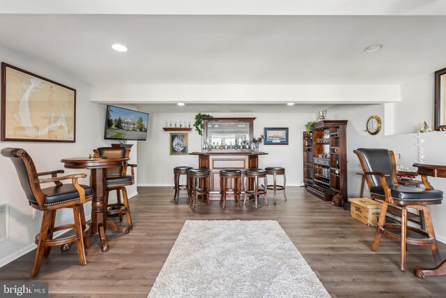 dining space featuring indoor bar and dark hardwood / wood-style floors