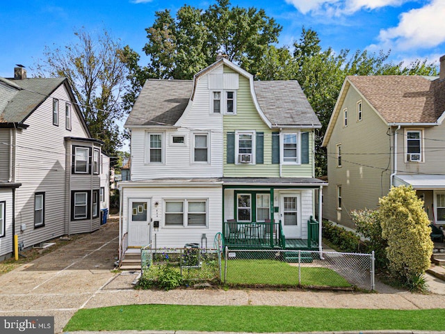 view of front of home featuring a fenced front yard, a gate, a porch, and a shingled roof