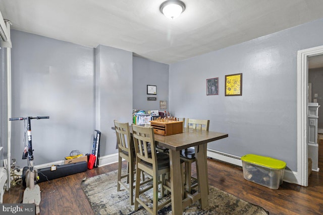 dining space with a baseboard radiator, wood finished floors, and baseboards