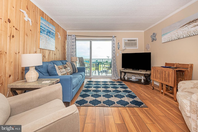 living room featuring light wood-type flooring, wood walls, a wall mounted air conditioner, and ornamental molding