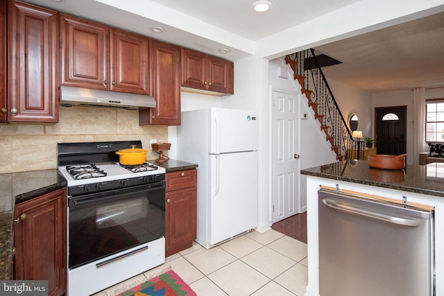 kitchen featuring light tile patterned floors, decorative backsplash, range with gas cooktop, stainless steel dishwasher, and white fridge