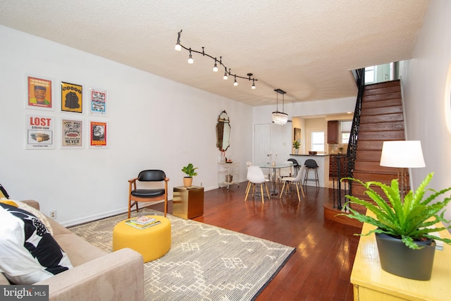 living room with track lighting, a textured ceiling, and hardwood / wood-style flooring