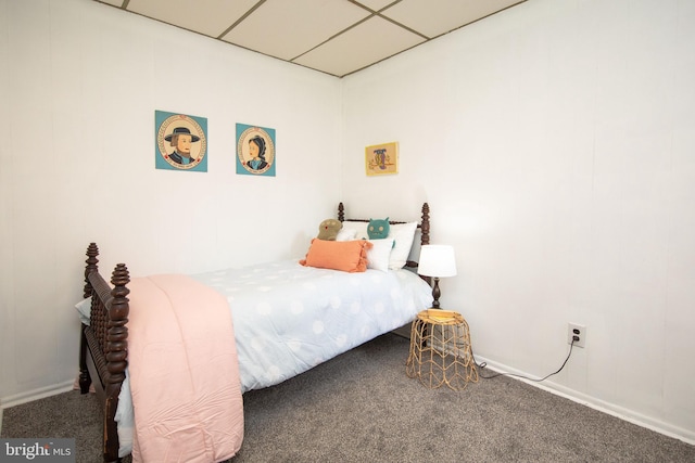 carpeted bedroom featuring a drop ceiling