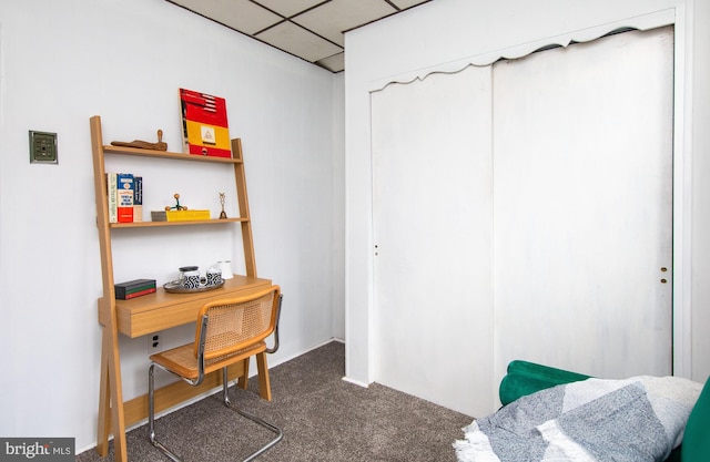 office space featuring a paneled ceiling and dark colored carpet