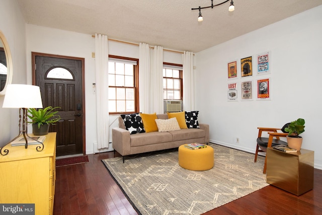 living room with dark hardwood / wood-style flooring, rail lighting, a textured ceiling, and cooling unit