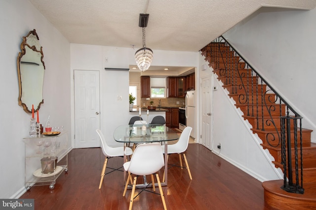 dining room featuring dark hardwood / wood-style flooring and a textured ceiling