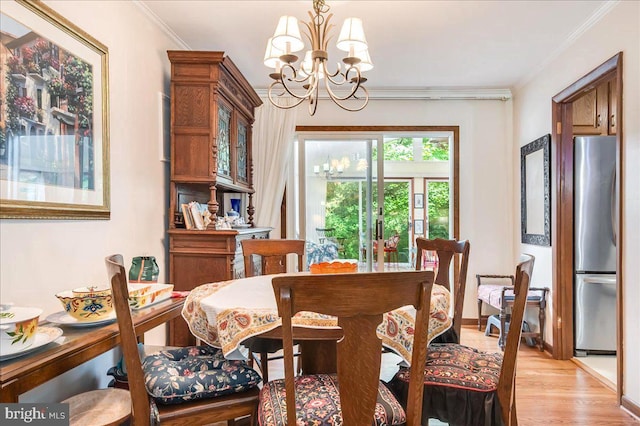 dining room with light wood-type flooring, a chandelier, and ornamental molding